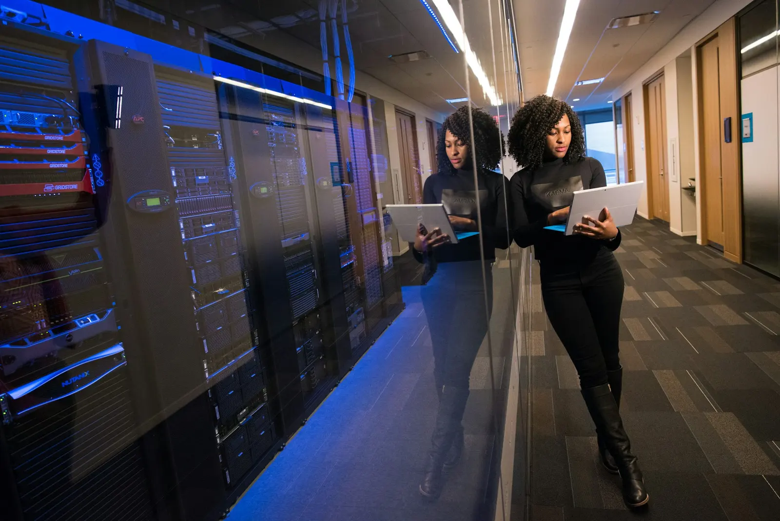 Two colleagues with a laptop walking a datacenter corridor between server racks