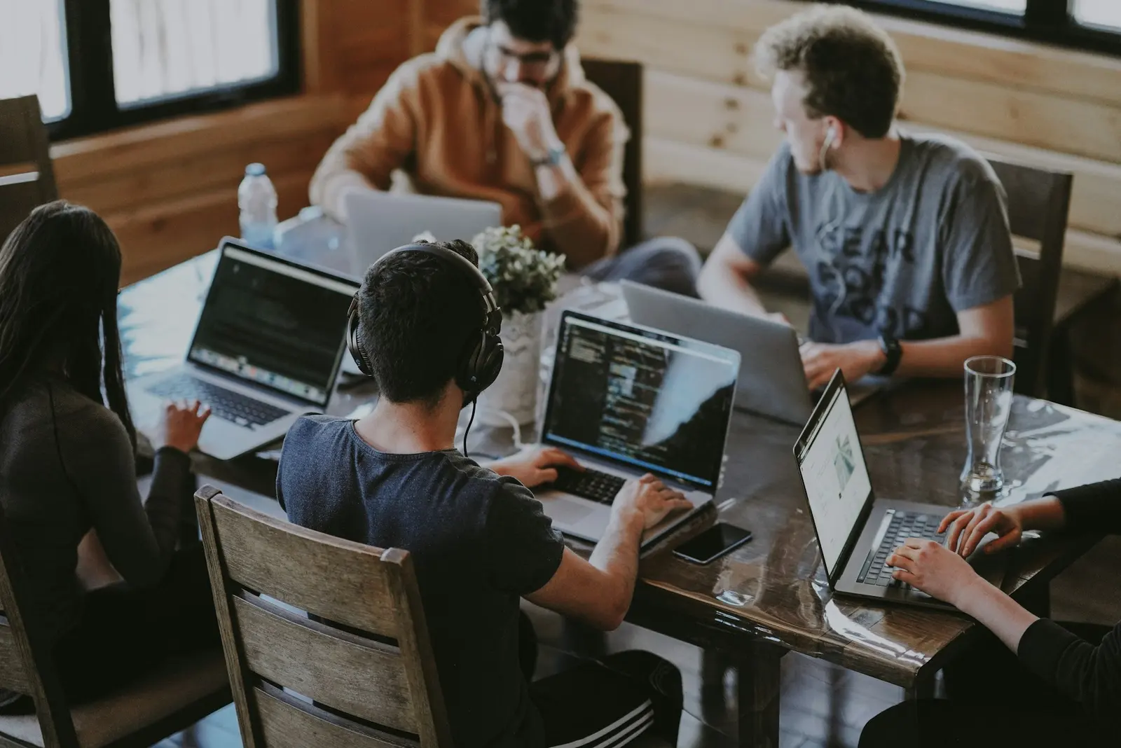 A team working together around a table of laptops